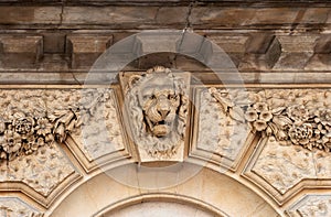Lion head relief on the facade of building. London, UK