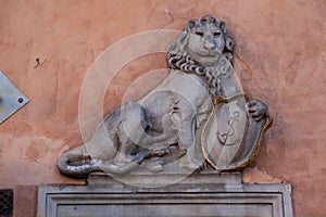 Lion holding a coat of arms on the facade of a buildng in old town market square, Warsaw, Poland