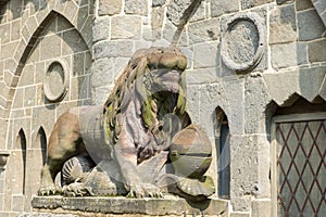 Lion with knight`s armor, stone sculpture, on entrance of Lions Castle, Kassel, Mountain  Park Wilhelmshoehe, Germany