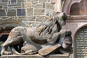 Lion with knight`s armor, stone sculpture, on entrance of Lions Castle, Kassel, Mountain  Park Wilhelmshoehe, Germany