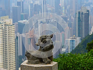 Lion sculpture against the backdrop of Hong Kong skyscrapers