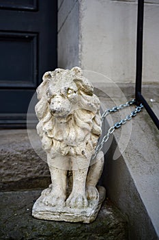 Lion sculpture made of stone or  gypsum chained in front of a house entrance in the old town of luebeck, germany