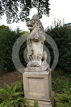 Lion statue carrying coat of arms on a plinth