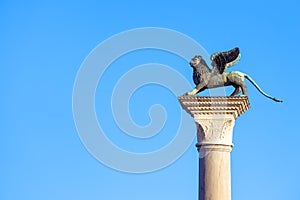 Lion statue at Piazza San Marco St Mark`s Square on blue sky background, Venice, Italy. This place is a tourist attraction of