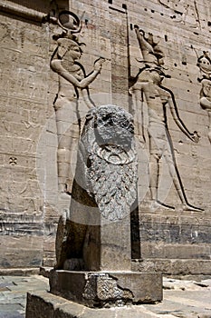 A lion statue sitting at the entrance of the first Pylon at the Temple of Isis on the island of Philae in Egypt.