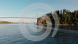 Lions Gate Bridge in Vancouver`s harbor with pleasure craft passing by next to Stanley Park. 4K 24FPS.