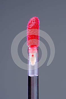 Lip Gloss Applicator with Scarlet Lip Gloss Close-Up on Grey Background