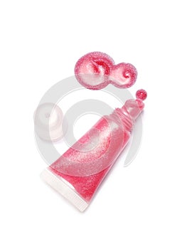 Lip gloss pink color from tube on white background