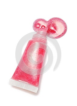 Lip gloss pink color from tube on white background