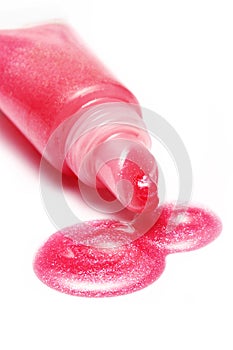 Lip gloss pink color from tube on white background photo