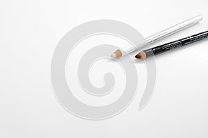 Lip pencil and eye liner makeup on a white background