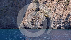 Lipari Island, mountain with caves in Mediterranean sea. Summer sunny day. Rippling blue water surface. Sicily, Italy