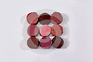 Lipstick  bullet macro.  Nine lipstick bullets slised and arranged on white background
