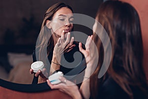 Lips Care. Woman applying moisturising cream on lips