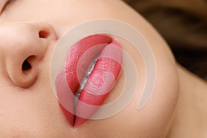 lips close-up made with permanent lip makeup with a delicate red pigment