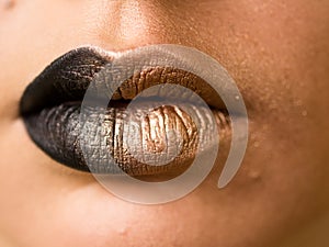 Lips make-up. Beauty high fashion trendy black with gold colour gradient lips makeup sample, mouth closeup.