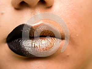 Lips make-up. Beauty high fashion trendy black with gold colour gradient lips makeup sample, mouth closeup.