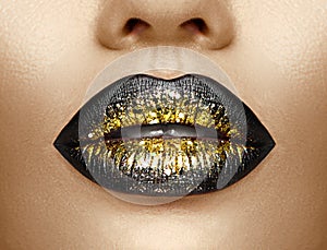 Lips makeup. Beauty high fashion gradient lips makeup sample, black with golden color. mouth. Lipstick photo