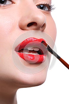 Make-up artist apply lipstick with brush, beauty concept photo