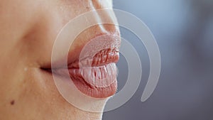 Lips moisturizing. Close up shot of moisturized female lips, unrecognizable woman applying nourishing balm, empty space