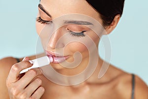 Lips Skin Care. Beautiful Woman Applies Lipbalm Protection On