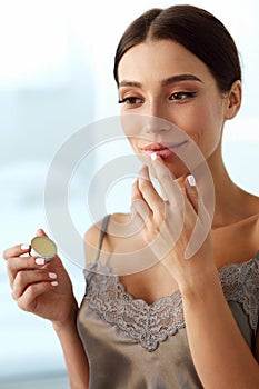 Lips Skin Care. Woman With Beauty Face Applying Lip Balm On