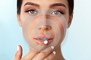 Lips Skin Care. Woman With Beauty Face Applying Lip Balm On