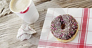Lipstick mark on coffee cup and chocolate doughnut with sprinkles