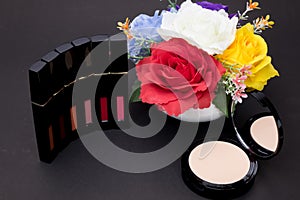 Lipstick, powder and flowers with cosmetics for women to make her