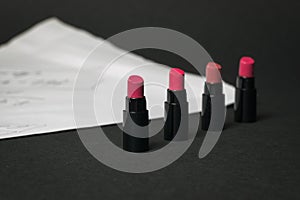 Lipstick samples on a white sheet on a black background.