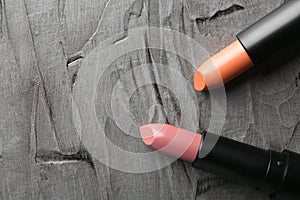 Lipsticks of different shades on grey background