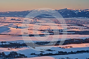 Liptov countryside and Low Tatras from Janosikov stol rock during winter sunset