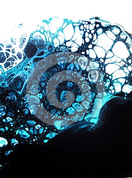 Liquid abstract acrylic paintings, mixing blue, black, white paints.
