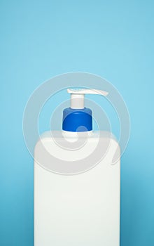 Liquid container for gel, lotion, cream, shampoo, bath foam. Cosmetic plastic bottle with blue dispenser pump on blue