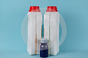 Liquid epoxy in bottles and blue dye on blue background. photo