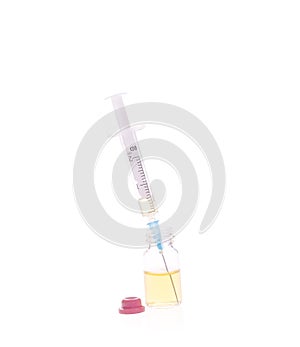 A liquid-filled syringe and a bottle