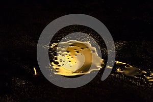 Liquid gold is spilled in a dark room