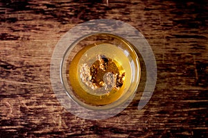 Liquid honey with honeycombs in a glass bowl