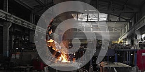 Liquid iron molten metal pouring in container, industrial metallurgical factory, foundry cast