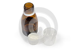 Liquid medicine in brown glass bottle and medicine measuring cup