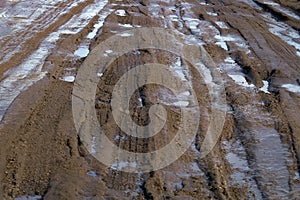 Liquid mud on a dirt road.Car tire tracks