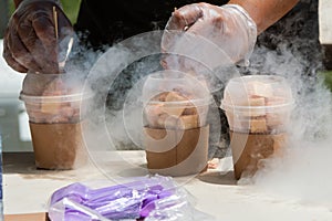 Liquid Nitrogen Steams As Man Prepares Frozen Treats At Festival photo