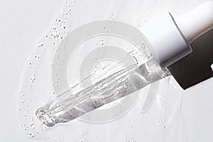 Liquid oil serum drop in pipette isolated on white background. Retinol, aha, bha acid, collagen skincare fluid, photo