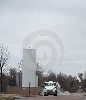 Liquid oxygen being unloaded from a semi truck into storage tanks at a medical facility in a residential district