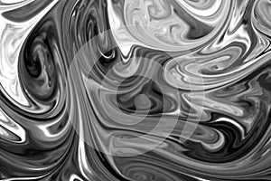 Liquid paints mixed together creating black and white abstract