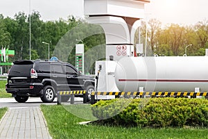 Liquid propane gas station. Black modern SUV car refueling tank with alternative power natural liquefied fuel