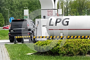 Liquid propane gas station. Black modern SUV car refueling tank with alternative power natural liquefied fuel