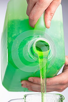 Liquid soap in plastic bottle, pouring by hands