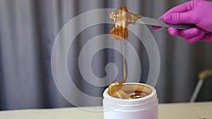 Liquid sugar for skin epilation. Close up shot. depilation and beauty concept - sugar paste or wax honey for hair