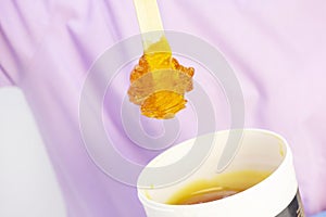 Liquid sugar for skin epilation. Close up shot. depilation and beauty concept - sugar paste or wax honey for hair removing